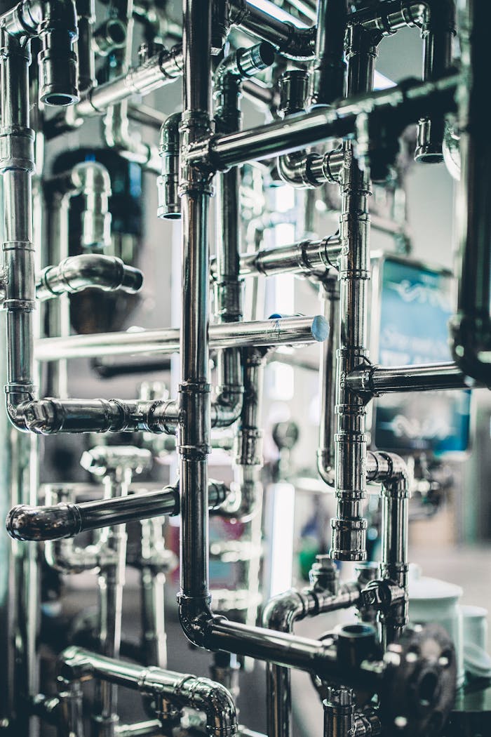 Close-up of complex stainless steel pipes in an industrial setting, showcasing modern engineering.